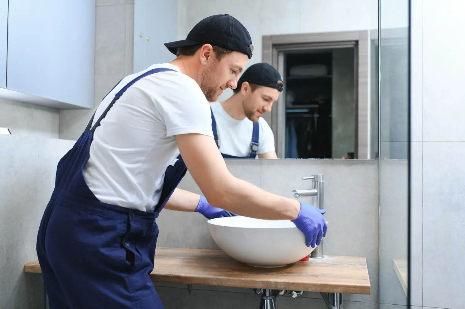 Junge Handwerker installieren Waschbecken im Badezimmer